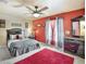 Bedroom with red accent wall, ceiling fan, and lots of natural light at 6932 Gray Catbird Loop, Wesley Chapel, FL 33545