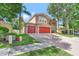 Spacious brick driveway with a two-car garage and well-maintained lawn with mature trees at 6932 Gray Catbird Loop, Wesley Chapel, FL 33545