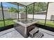 Enclosed patio showcasing a luxurious hot tub with tile flooring and a view of the backyard at 6932 Gray Catbird Loop, Wesley Chapel, FL 33545
