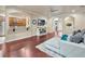 Open-concept living area with hardwood floors, a white sofa, and a view into the kitchen at 6932 Gray Catbird Loop, Wesley Chapel, FL 33545