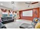 Home theater with projector screen, comfortable seating, and large windows for natural light at 6932 Gray Catbird Loop, Wesley Chapel, FL 33545