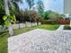 Expansive backyard featuring a circular brick patio and lush greenery, perfect for outdoor relaxation at 801 Leeward Way, Palm Harbor, FL 34685