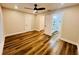 Bright bedroom featuring wood-look floors, ceiling fan, and ensuite bathroom at 801 Leeward Way, Palm Harbor, FL 34685