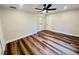 Neutral bedroom featuring wood floors, white trim, and a modern ceiling fan at 801 Leeward Way, Palm Harbor, FL 34685