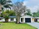 Charming single-story home featuring a well-manicured lawn, fresh exterior paint and lush landscaping at 801 Leeward Way, Palm Harbor, FL 34685