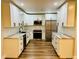Bright kitchen features white cabinets, stainless appliances, and wood-look flooring at 801 Leeward Way, Palm Harbor, FL 34685