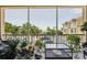 Comfortable screened-in porch with view of the community pool and lush landscaping at 1061 Pinellas Bayway S, Tierra Verde, FL 33715