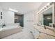 Bright bathroom with double sinks, soaking tub, and walk-in shower at 1061 Pinellas Bayway S, Tierra Verde, FL 33715