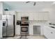 Updated kitchen features stainless steel appliances and white cabinetry at 1061 Pinellas Bayway S, Tierra Verde, FL 33715