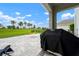Covered back patio featuring a stone-paved seating area overlooking a lush, green backyard at 3255 Hilltop Cir, Bradenton, FL 34211