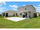 Spacious backyard features a stone patio, covered porch, lush green lawn and barbecue grill at 3255 Hilltop Cir, Bradenton, FL 34211