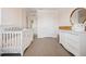 Bright Bedroom with carpeting, modern crib, white dresser and wall mirror at 3255 Hilltop Cir, Bradenton, FL 34211