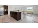 Modern kitchen island with dark cabinets and seating, open to a cozy living room at 3255 Hilltop Cir, Bradenton, FL 34211