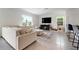 Bright living room with a large sectional sofa, TV, and tile flooring at 3255 Hilltop Cir, Bradenton, FL 34211