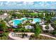 Aerial shot of a large swimming pool with sun loungers and cabanas, surrounded by lush landscaping at 3255 Hilltop Cir, Bradenton, FL 34211