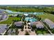 Aerial view of an elaborate resort style pool with lounge chairs, mature landscaping, and outdoor eating area at 3255 Hilltop Cir, Bradenton, FL 34211
