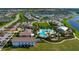 Birds eye view of a multi-sectioned pool with many chairs and umbrellas surrounded by community homes at 3255 Hilltop Cir, Bradenton, FL 34211