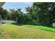 Lush backyard featuring a lawn and wooded area, partially enclosed by a white picket fence at 4428 Winding River Drive, Valrico, FL 33596