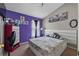 Bright bedroom showcasing purple accent wall and neutral decor complemented by natural light and contemporary furnishings at 4428 Winding River Drive, Valrico, FL 33596
