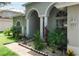 Landscaped front exterior with plants and a walkway to the columned entryway at 4428 Winding River Drive, Valrico, FL 33596