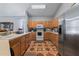 Bright kitchen provides ample wood cabinet storage and counter space with stainless refrigerator at 4428 Winding River Drive, Valrico, FL 33596