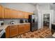 Galley kitchen features wood cabinets, stainless appliances, and access to the laundry room at 4428 Winding River Drive, Valrico, FL 33596