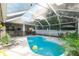 Inviting screened-in pool area with outdoor seating, lush plants, and a charming covered patio at 4428 Winding River Drive, Valrico, FL 33596