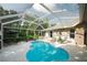 Inviting screened-in pool area with comfortable lounge chairs and an umbrella table for relaxation at 4428 Winding River Drive, Valrico, FL 33596