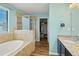 Spa-like bathroom with a soaking tub, a glass-enclosed shower, and stylish granite countertops at 4502 Banyan Tree Pl, Riverview, FL 33578