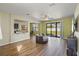Cozy living room with sliding glass doors to backyard, wood-look floors, and a modern ceiling fan at 4502 Banyan Tree Pl, Riverview, FL 33578