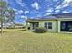Green home featuring a screened-in patio, green lawn, and solar panels for energy efficiency at 1718 Trailwater St, Ruskin, FL 33570