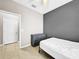 Simple bedroom featuring tiled floors, a modern bed frame, and a gray accent wall at 1718 Trailwater St, Ruskin, FL 33570