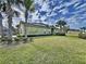 Green home with well-manicured lawn and tropical palm trees, with solar panels for energy at 1718 Trailwater St, Ruskin, FL 33570