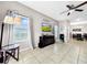 Open living room area with light tile flooring, ceiling fan, and entertainment center with a TV at 1718 Trailwater St, Ruskin, FL 33570