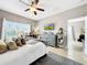 Bright main bedroom featuring a decorative dresser, a ceiling fan, and ample natural light from a large window at 1718 Trailwater St, Ruskin, FL 33570