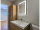 Bathroom featuring new vanity, modern lighting and wood-style cabinet at 4202 W Bay Vista Ave, Tampa, FL 33611