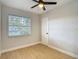 Cozy bedroom with ceiling fan, window, and white trim and new modern floors at 4202 W Bay Vista Ave, Tampa, FL 33611