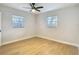Bedroom with two windows, wood flooring, and a ceiling fan at 4202 W Bay Vista Ave, Tampa, FL 33611