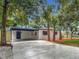 Newly updated exterior with a modern paint scheme, mature palm trees, and a convenient carport at 4202 W Bay Vista Ave, Tampa, FL 33611