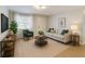 Bright living room features a sofa, chair, accent table, and herringbone area rug at 4202 W Bay Vista Ave, Tampa, FL 33611
