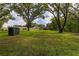 Lush backyard with mature trees, a storage shed, and a view of the home's exterior at 4401 W Sam Allen Rd, Plant City, FL 33565