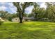 Spacious backyard with mature trees, a screened-in patio, and ample green space at 4401 W Sam Allen Rd, Plant City, FL 33565