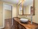 Traditional bathroom with a wooden vanity and bowl sink next to a doorway at 4401 W Sam Allen Rd, Plant City, FL 33565