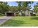 Charming single-story home with a two-car carport, stone accent wall and verdant green front lawn at 4401 W Sam Allen Rd, Plant City, FL 33565