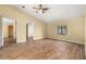 Living room with wood flooring, a ceiling fan, a window, and view into hallway at 4401 W Sam Allen Rd, Plant City, FL 33565