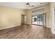 A living room with a vaulted ceiling, wood floors, and sliding glass doors leading to the pool area at 4401 W Sam Allen Rd, Plant City, FL 33565