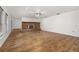 Spacious living room featuring a brick fireplace, ceiling fan and wood-look floors at 4401 W Sam Allen Rd, Plant City, FL 33565