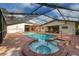 Enclosed pool and hot tub featuring brick accents and a bright, sunny enclosure at 4401 W Sam Allen Rd, Plant City, FL 33565