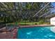Enclosed pool and hot tub with brick accents and views of the spacious, tree-lined yard at 4401 W Sam Allen Rd, Plant City, FL 33565