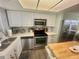 Contemporary kitchen with stainless steel appliances, stylish backsplash, and ample counter space at 6009 Sea Ranch Dr # 203, Hudson, FL 34667